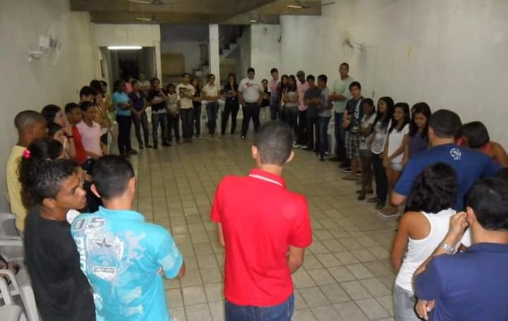 Jovens reunidos em círculo em um encontro da comunidade